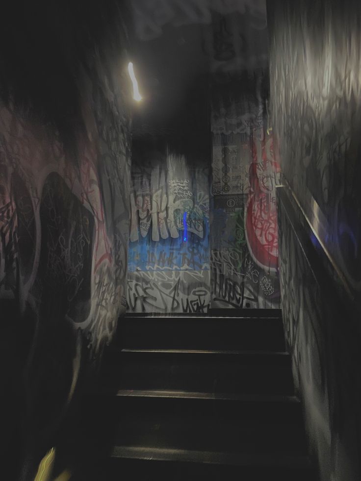 the stairs are covered with graffiti in this dark room