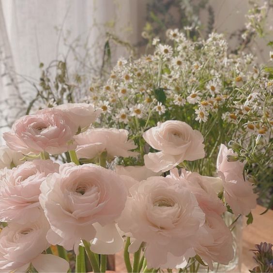 some pink flowers are in a glass vase