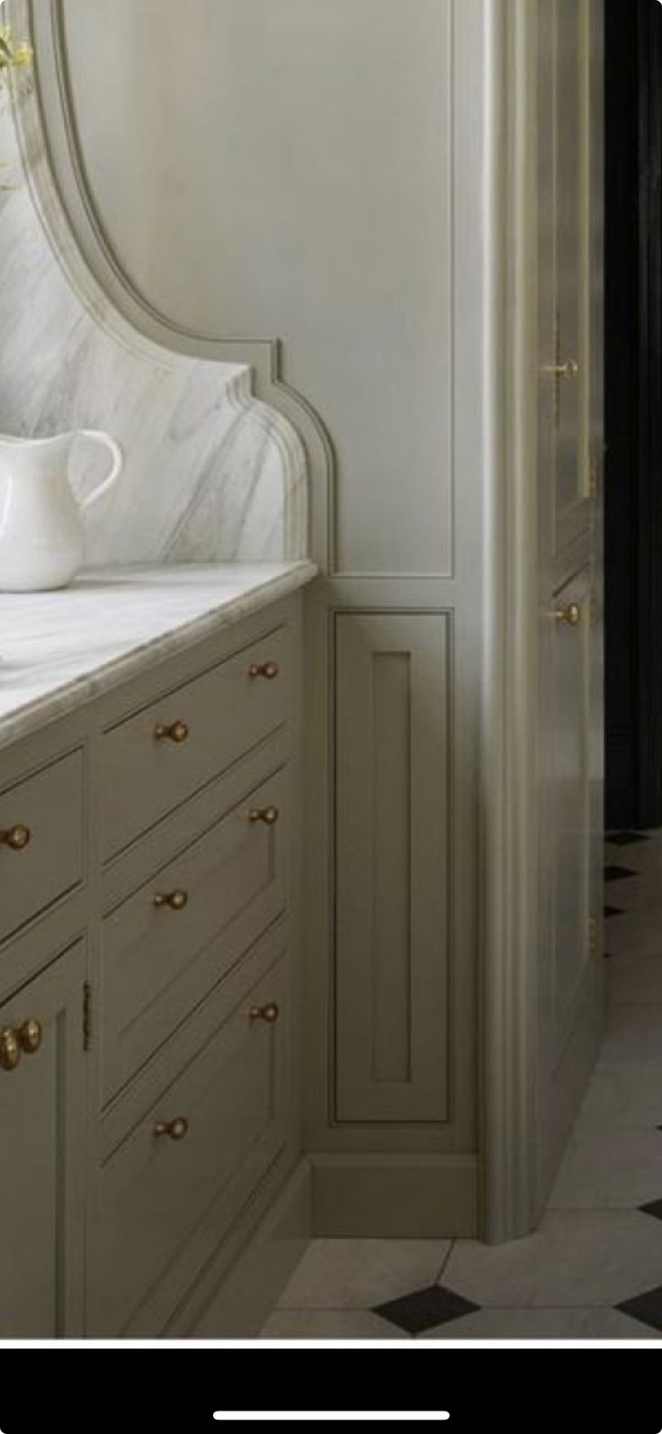 a kitchen with marble counter tops and white cabinets