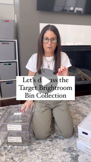 a woman sitting on the floor holding up a sign that says let's d pass the target bathroom bin collection