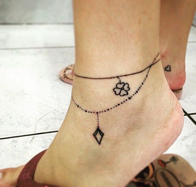 a woman's foot with a small tattoo on the ankle and an arrow in the middle