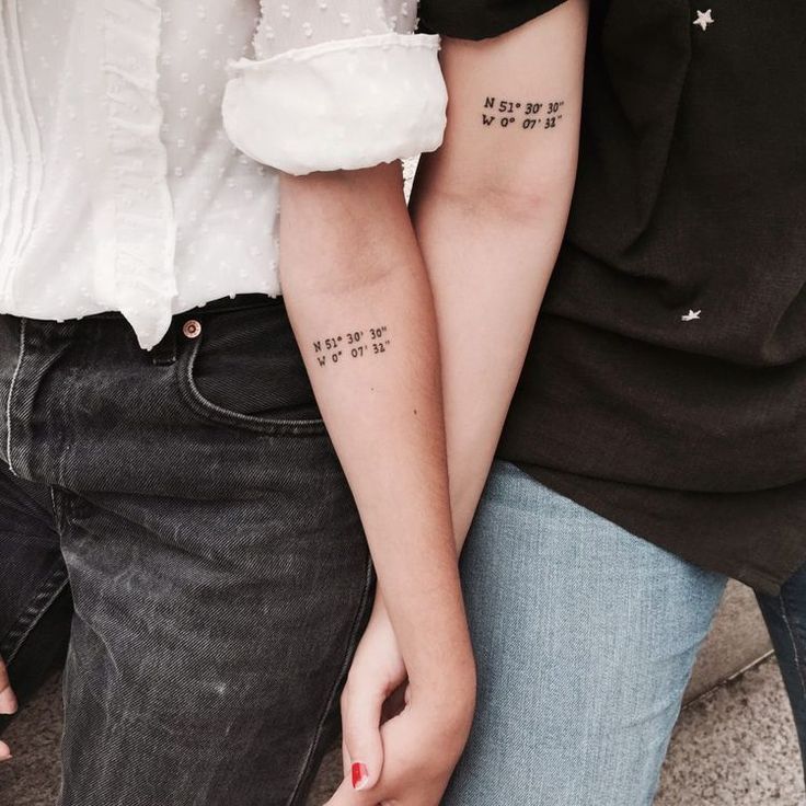 two people are holding hands with tattoos on their arms and one has the word love written on it