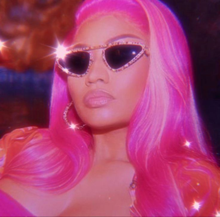 a woman with bright pink hair and sunglasses