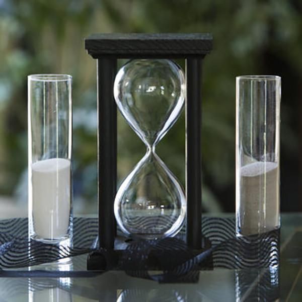 three hourglasses sitting on top of a glass table