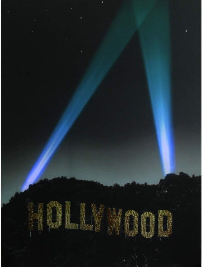 two blue lights shining over the hollywood sign at night with stars in the sky above