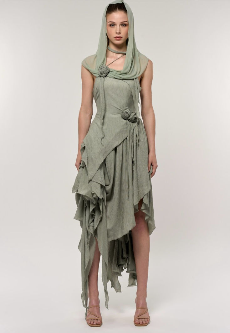 This set includes a sleeveless, fitted bodicean top and an asymmetrical skirt, featuring cascading ruffles in the same seafoam green ribbed fabric. The crisp and enchanting green, filled with vibrant vitality, evokes the sense of everything springing back to life and flourishing. These ruffles add volume and create a flowing, dynamic look as they unevenly descend to varying lengths around the skirt, with some layers reaching down to the ankle. Fitted Asymmetrical Ruffle Dress, Green Asymmetrical Neckline Pre-draped Dress, Avant-garde Sleeveless Dress For Spring, Fitted Green Dress With Asymmetrical Hem, Green Fitted Dress With Asymmetrical Hem, Avant-garde Sleeveless Spring Dress, Sage Fitted Sleeveless Dress, Sage Sleeveless Fitted Dress, Green Asymmetrical Ruched Dress