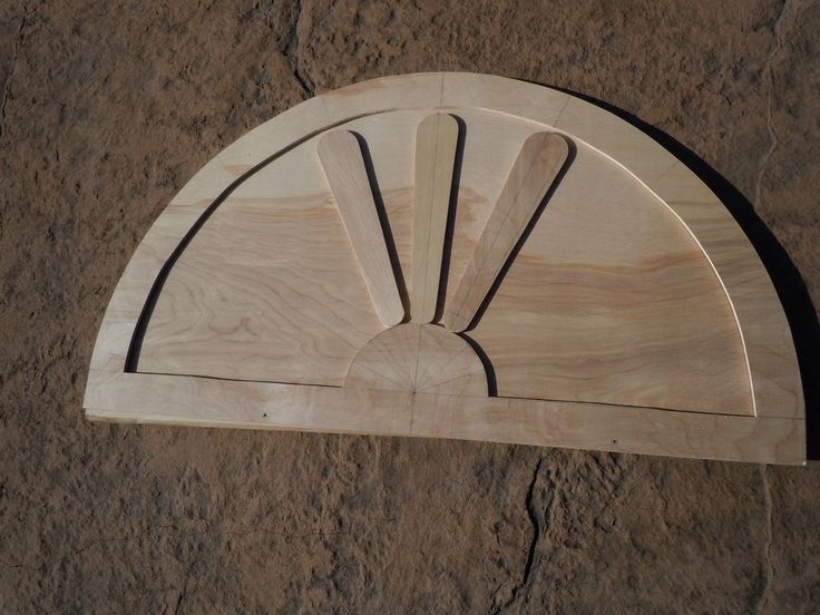 a wooden plaque with an arch on the side in front of a stone wall,