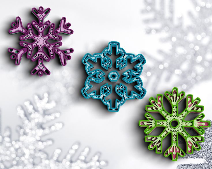 three snowflakes sitting on top of a white table