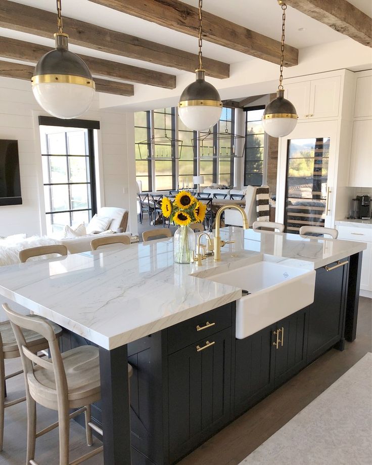 a large kitchen with an island and sunflowers in the vase on the counter