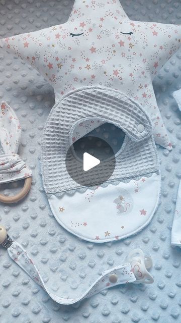 a baby's bib and pacifier laying on top of a blanket