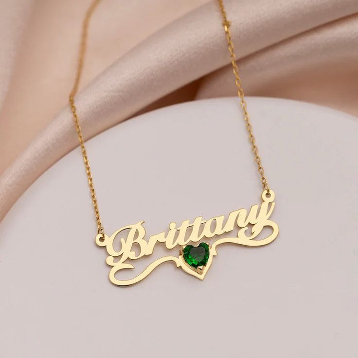 Unveil Your Unique Elegance with Our Shimmering Name Necklace with Birthstone Celebrate the special moments in life with a piece that embodies elegance and thoughtfulness. Our Shimmering Name Necklace with Birthstone is a true testament to fine craftsmanship, meticulously fashioned from premium sterling silver or 18k gold plating. This minimalist masterpiece is the ideal gift for birthdays, anniversaries, or any occasion that calls for something extraordinary. What makes this necklace truly special? It's the personal touch that transforms it into a cherished keepsake. Customize it with a name, a significant date, or a meaningful word, making it a unique symbol of your love and thoughtfulness. Our Shimmering Name Necklace with Birthstone is more than just jewelry – it's a heartfelt gift tha Gold Jewelry For Formal Occasions With May Birthstone, Elegant Name Necklace For Valentine's Day Gift, Elegant Heart-shaped Name Necklace As Gift For Her, Elegant Heart-shaped Name Necklace For Her, Luxury Gold Birthstone Necklace Gift, Valentine's Day Gold Jewelry With Gemstones, Valentine's Day Gold Gemstone Jewelry, Elegant Diamond Name Necklace For Gift, Personalized Elegant Heart Pendant Name Necklace