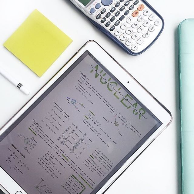 a tablet computer sitting on top of a white table next to a calculator