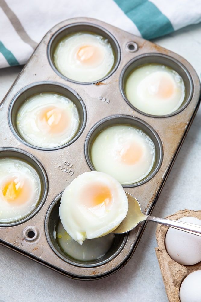 eggs are being cooked in a muffin tin