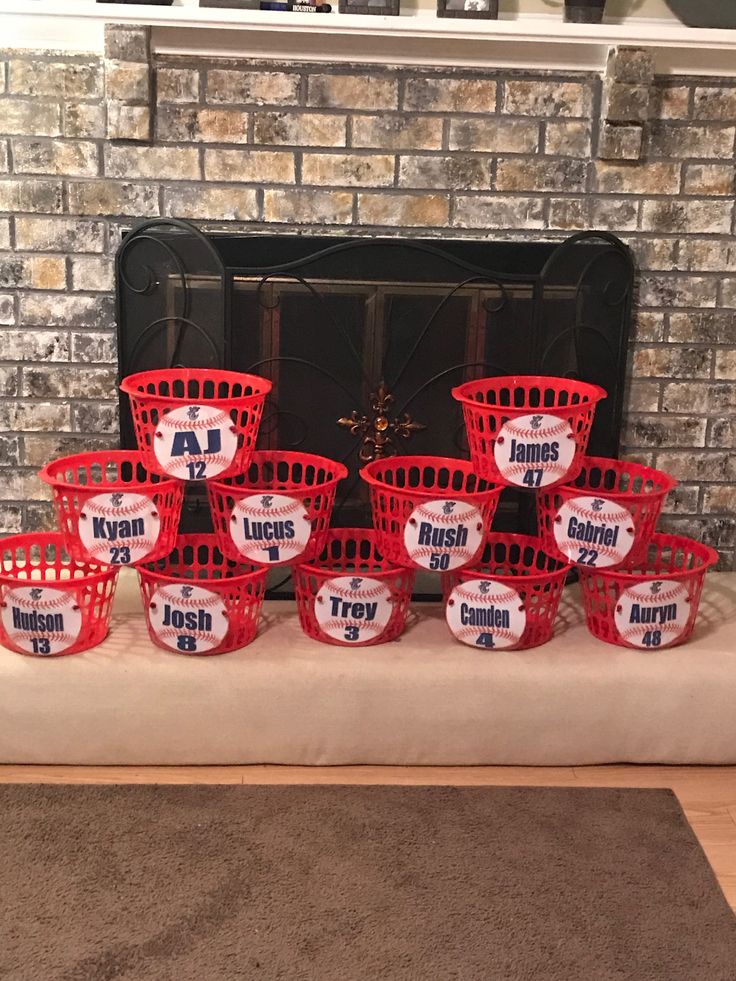 red baskets sitting in front of a fire place filled with baseballs and other items