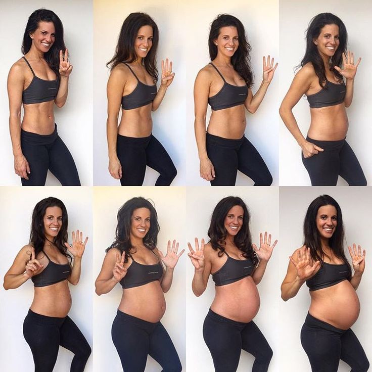 a pregnant woman poses for the camera with her hands up