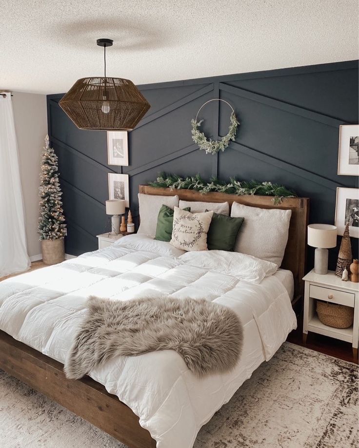 a bedroom with a large bed covered in white blankets and pillows, surrounded by christmas decorations