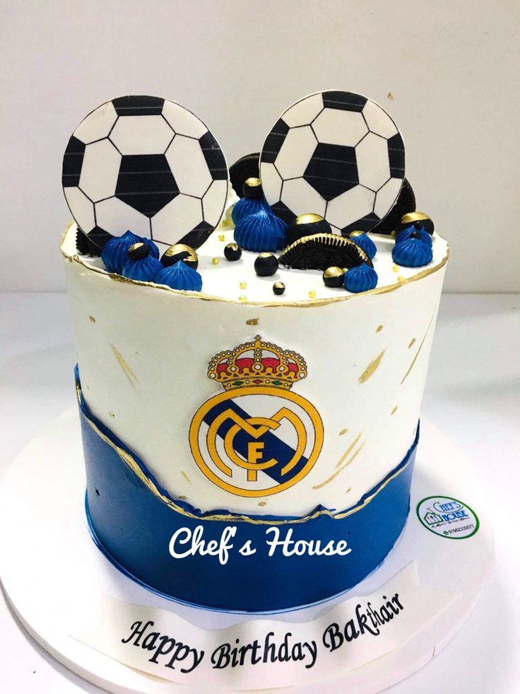 a birthday cake with soccer balls and tassels in the shape of a hat