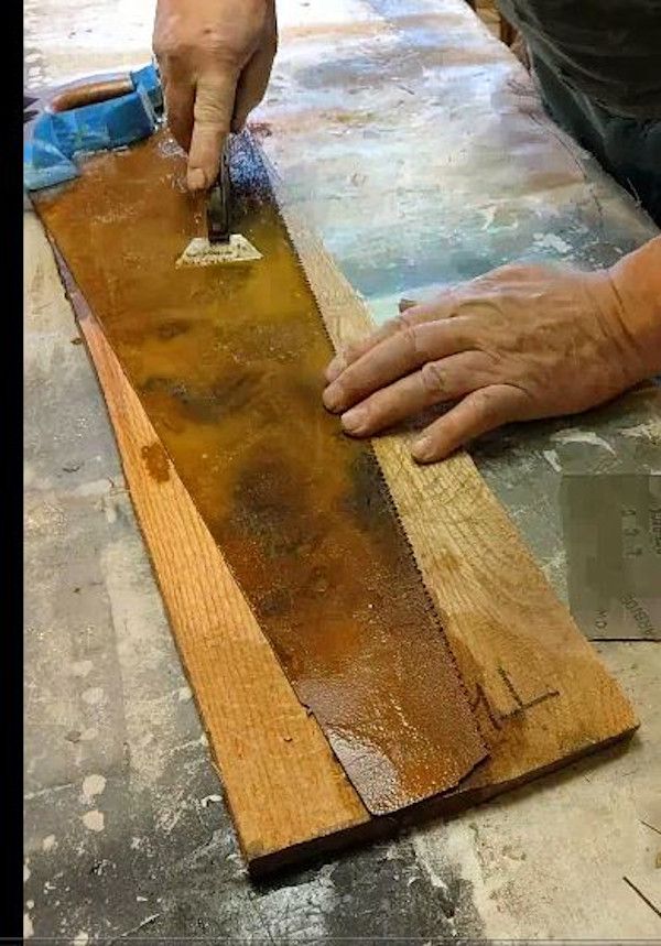 a man is sanding wood on the floor