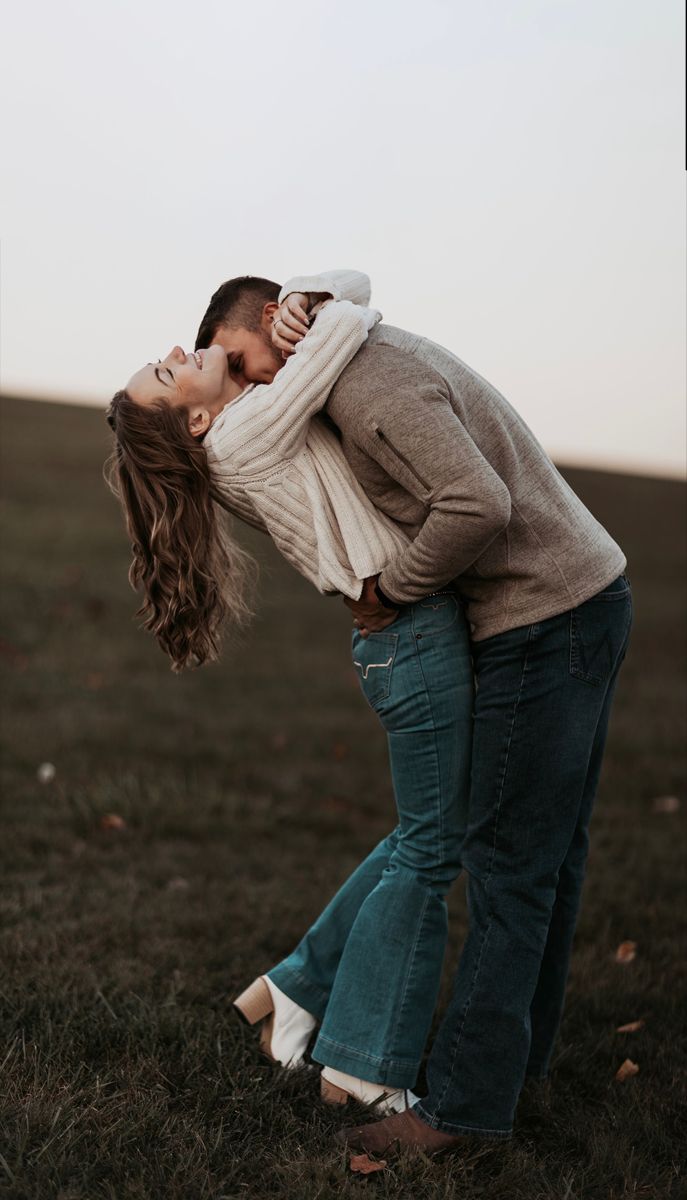 a man and woman kissing in a field