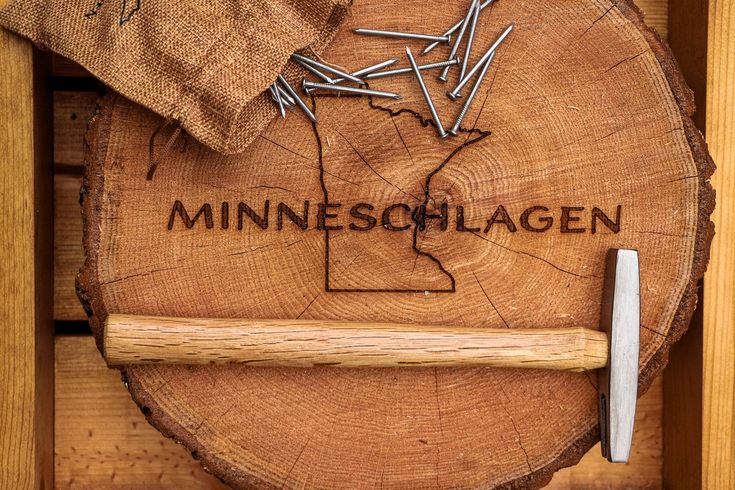 a piece of wood with the word minnesota on it and a hammer sticking out of it