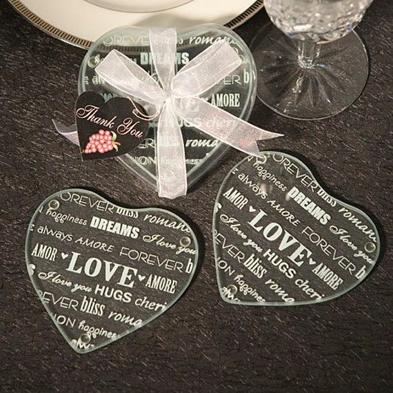 two heart shaped glass coasters sitting on top of a table next to a plate