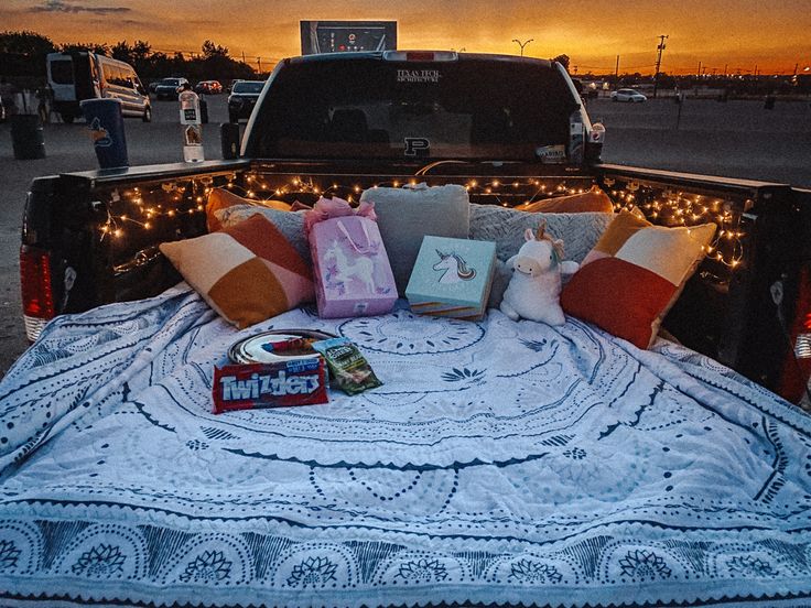 a bed in the back of a pick up truck with pillows and blankets on it