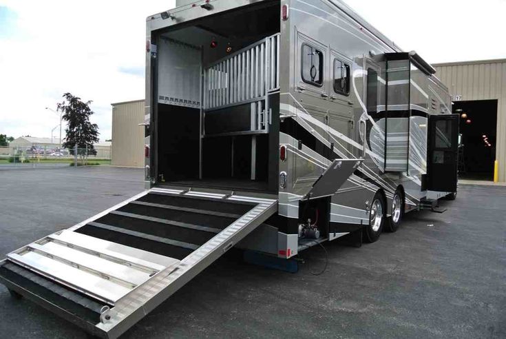 a trailer that is parked in a parking lot with the door open and stairs down