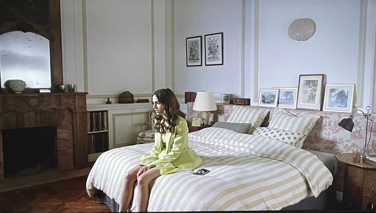 a woman sitting on top of a bed in a bedroom