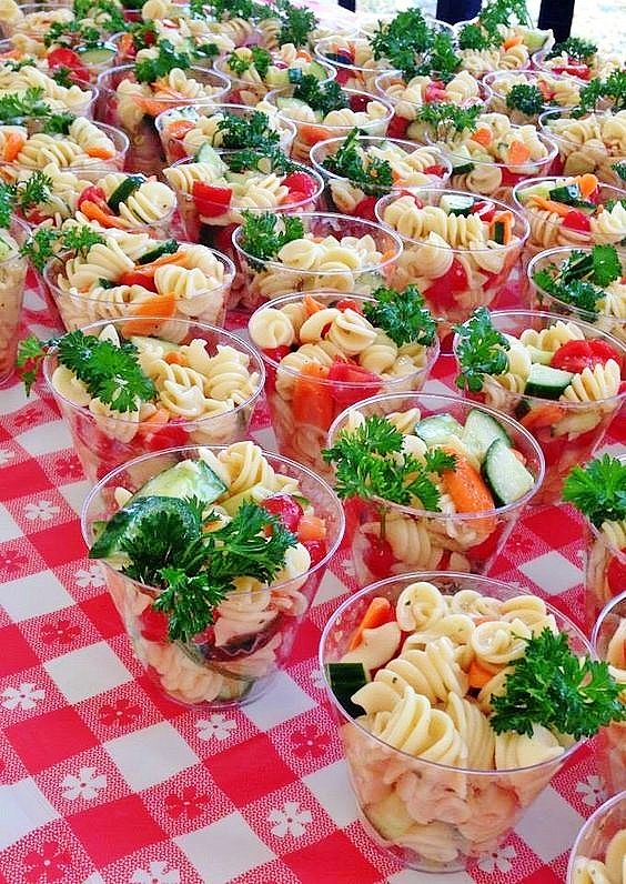 there are many small cups with food in them on the checkered tablecloths