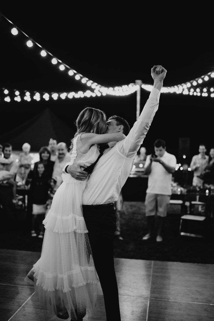 a bride and groom dance together on the dance floor at their wedding reception in black and white