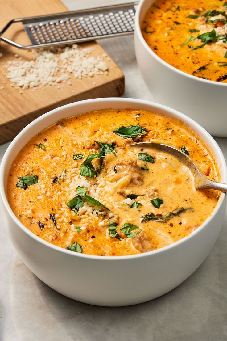 two white bowls filled with soup on top of a table