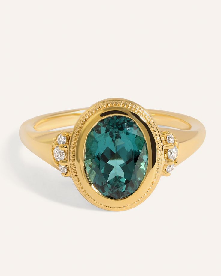 The most incredible shade of deep teal - a rarity in the world of Tourmalines. A 1.85ct oval AAA quality Brazilian Tourmaline from the Aracuai Mine is set in a unique milgrain bezel atop a tapered band. 0.08tcw SI clarity GH color side Diamonds add a touch of sparkle, beautifully contrasting the deep hue of the center Timeless Green Rings With Accent Stones, Luxury Diamond Ring With Emerald Accent Stones, Luxury Cluster Ring With Round Cut Gemstone, Exquisite 14k Gold Rings For Formal Occasions, Timeless Yellow Gold Oval Emerald Ring, Timeless Yellow Gold Emerald Ring With Oval Shape, Elegant Green Topaz Ring, Round Cut, Exquisite Diamond Ring With Polished Finish, Elegant Green Topaz Round Cut Ring