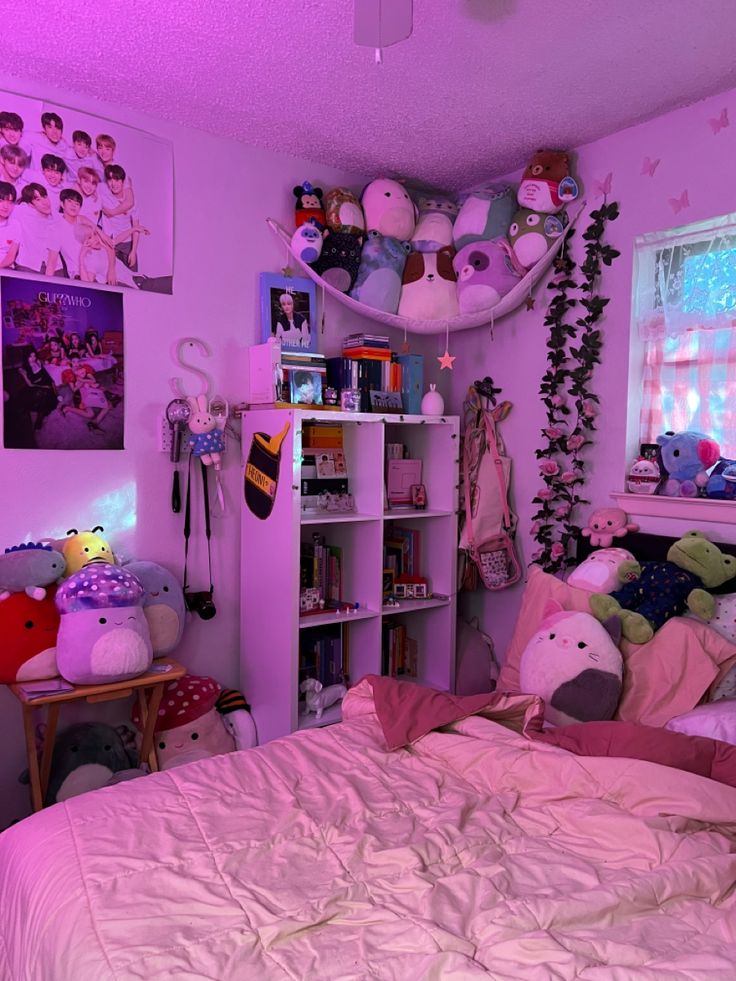 a bedroom with pink walls and lots of stuffed animals on the shelves above the bed