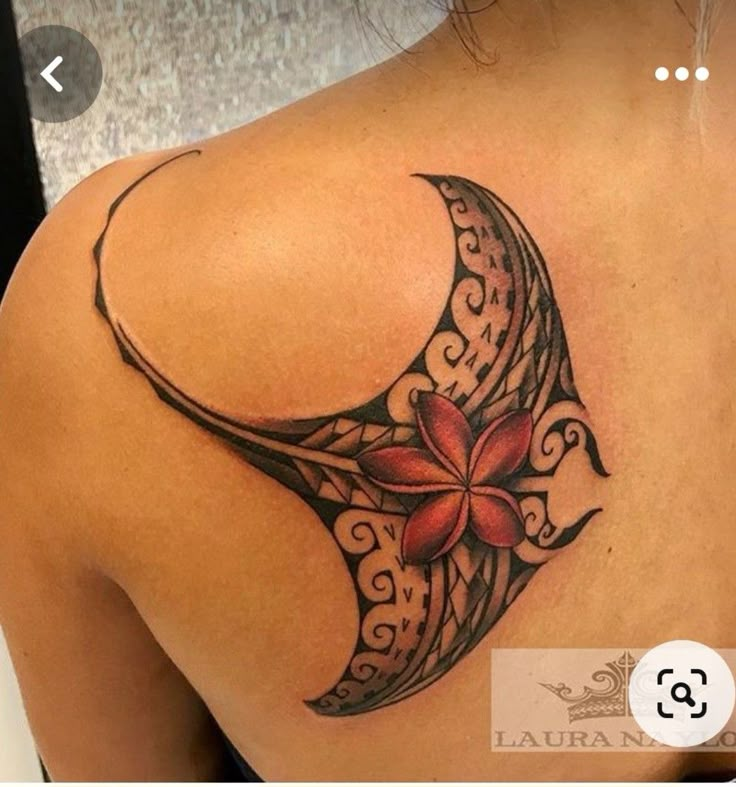 the back of a woman's shoulder with a flower and crescent tattoo on it