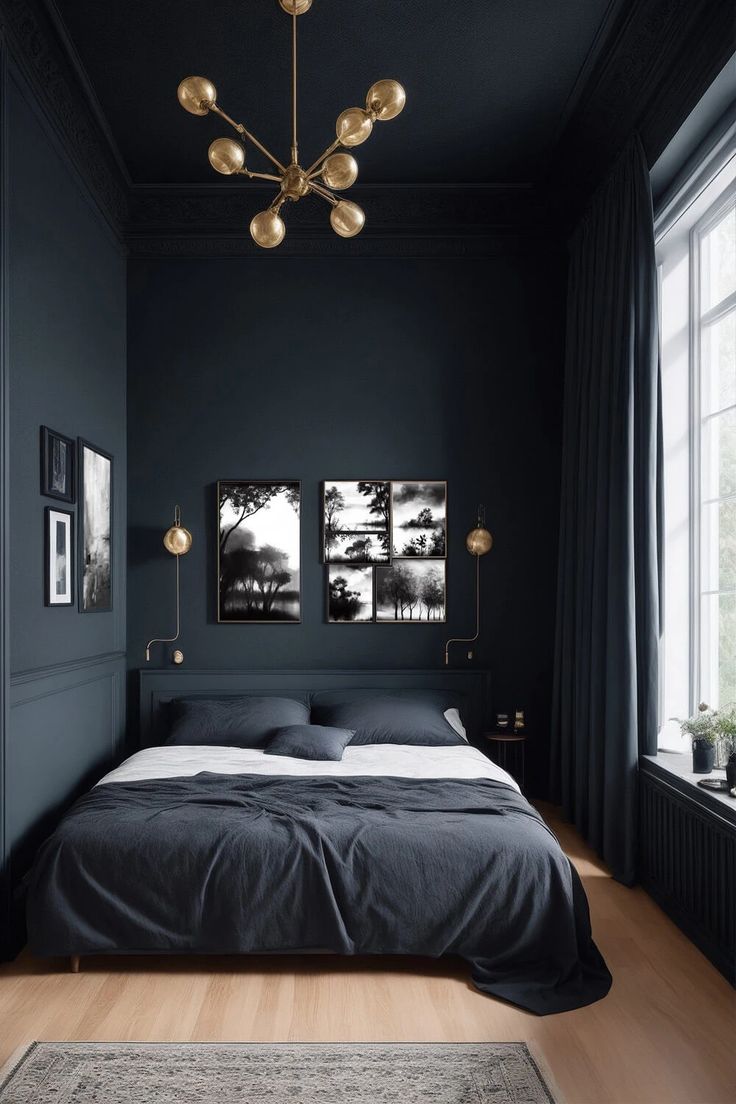 a bedroom with black walls and wooden floors, two paintings on the wall above the bed