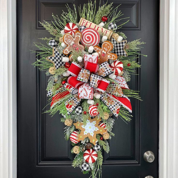 a christmas wreath on the front door with candy canes, candies and cookies