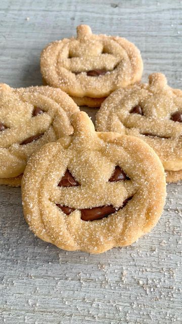 four cookies with faces on them sitting on a table