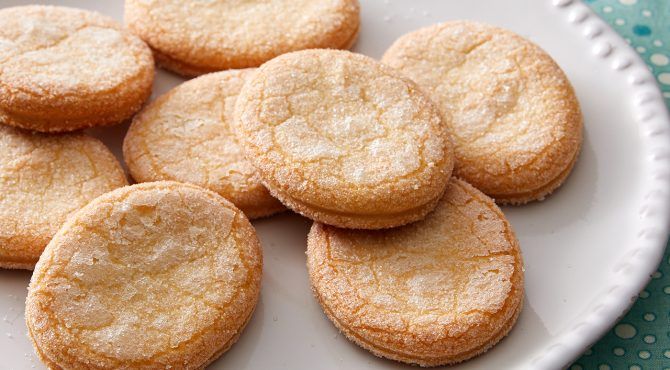 a white plate topped with sugar cookies on top of a blue and white table cloth