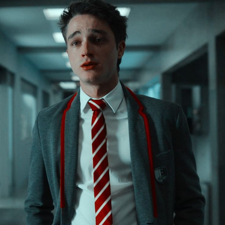 a man wearing a red and white striped tie in an office hallway with his mouth open