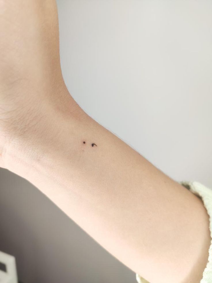 a woman's arm with a tiny tattoo on the left side of her body