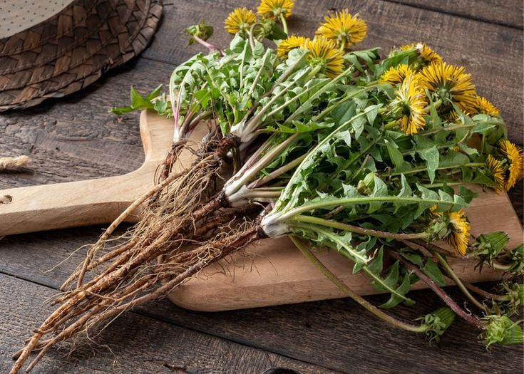 a wooden cutting board topped with lots of green and yellow flowers