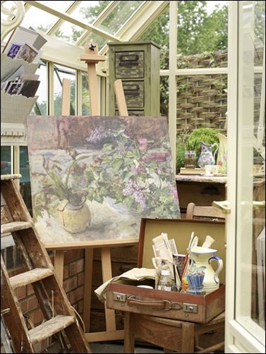 an artist's studio with easel and paintings