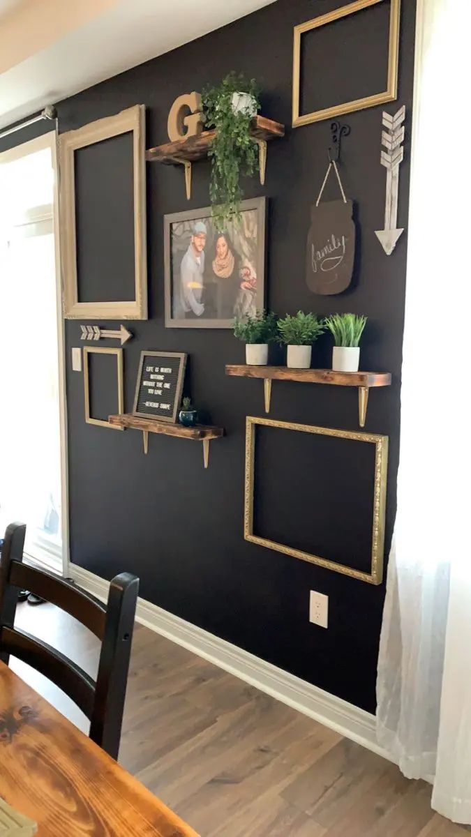 a dining room wall decorated with pictures, plants and chalkboard letters on the walls