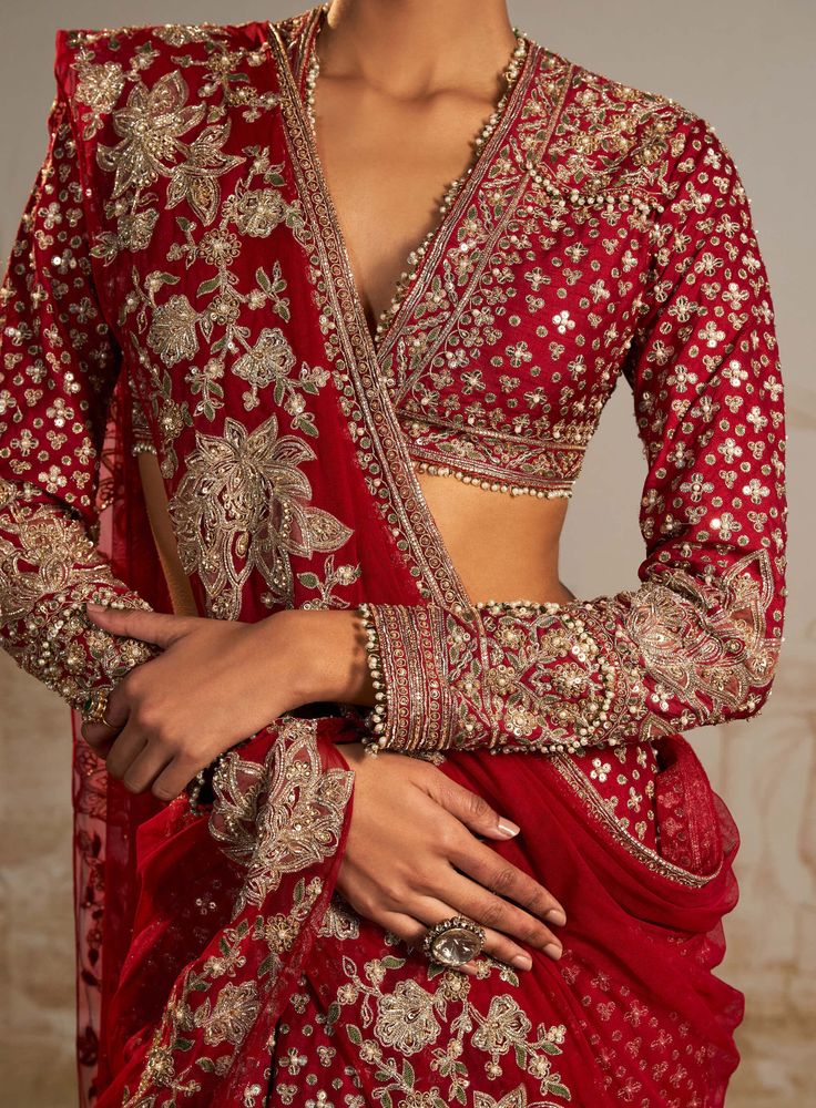 Embark on a sartorial journey with this red tree motif sari skirt set, where persian-inspired tree motifs narrate the emotional voyage of a bride. In a captivating red hue, the ensemble features a meticulously embroidered sari skirt, full-sleeves blouse, and an intricately detailed net dupatta. This versatile set, a fusion of tradition and modernity, is tailor-made for festive occasions, with the embroidered dupatta offering styling freedom. More than just attire, it's a bridal and trousseau ess Full Sleeves Designer Blouse, Red Full Sleeve Blouse, Red Sari Wedding, Red Saree Look Modern, Modern Lehenga Designs Style, Full Sleeve Saree, Bridal Sarees For Wedding, Bridal Red Saree, Red Saree Bridal