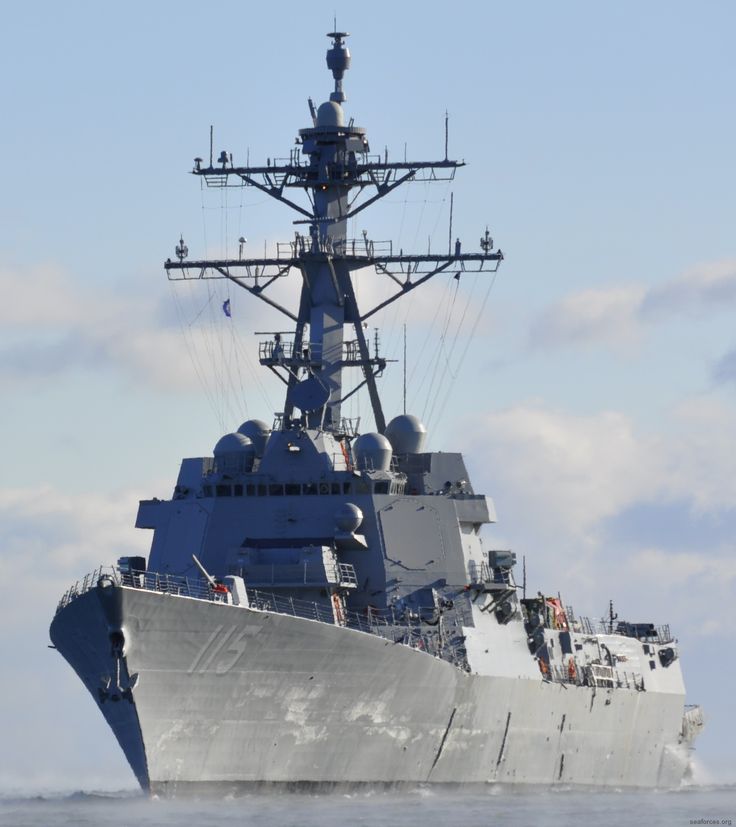 a navy ship sailing in the ocean on a sunny day