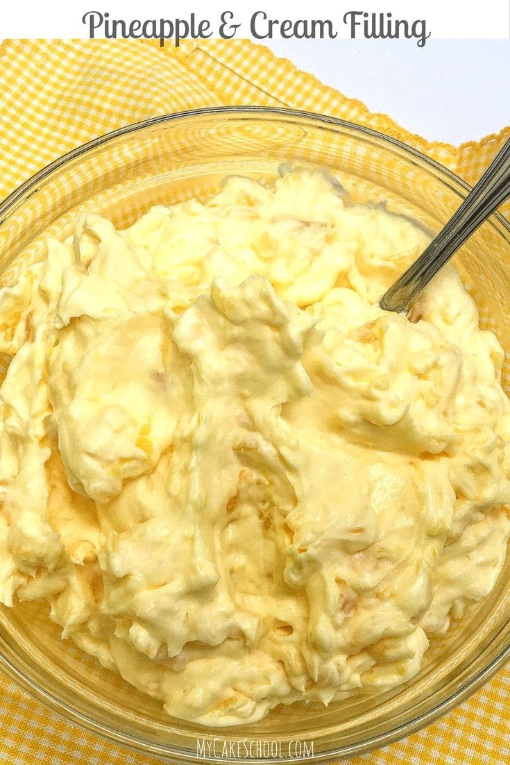 a glass bowl filled with cream filling on top of a yellow checkered table cloth