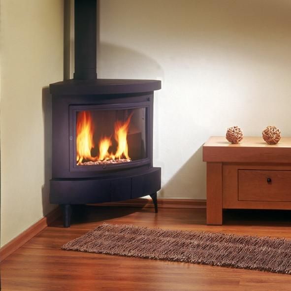 a wood burning stove in a living room next to a coffee table and rug on the floor