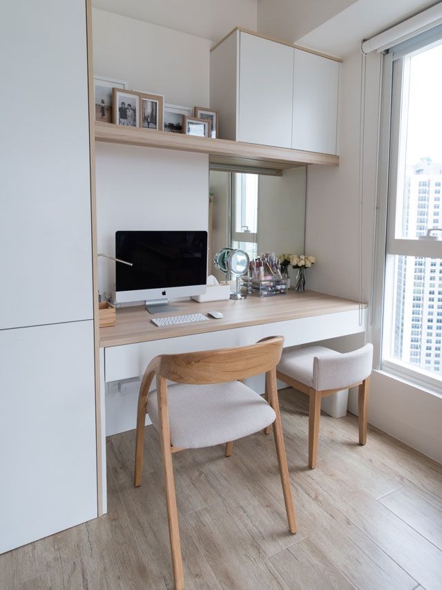 a white desk with a computer on it in front of a window and some chairs