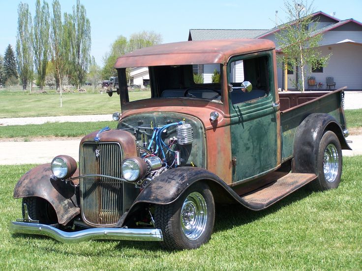 an old truck is parked in the grass