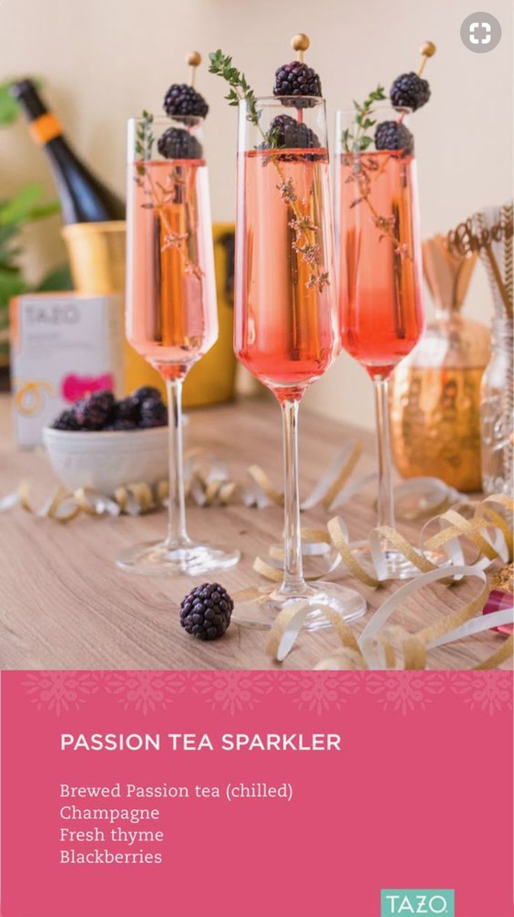 three glasses filled with champagne and blackberries on top of a table